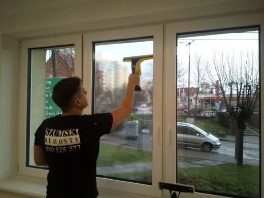 mężczyzna myjący okno